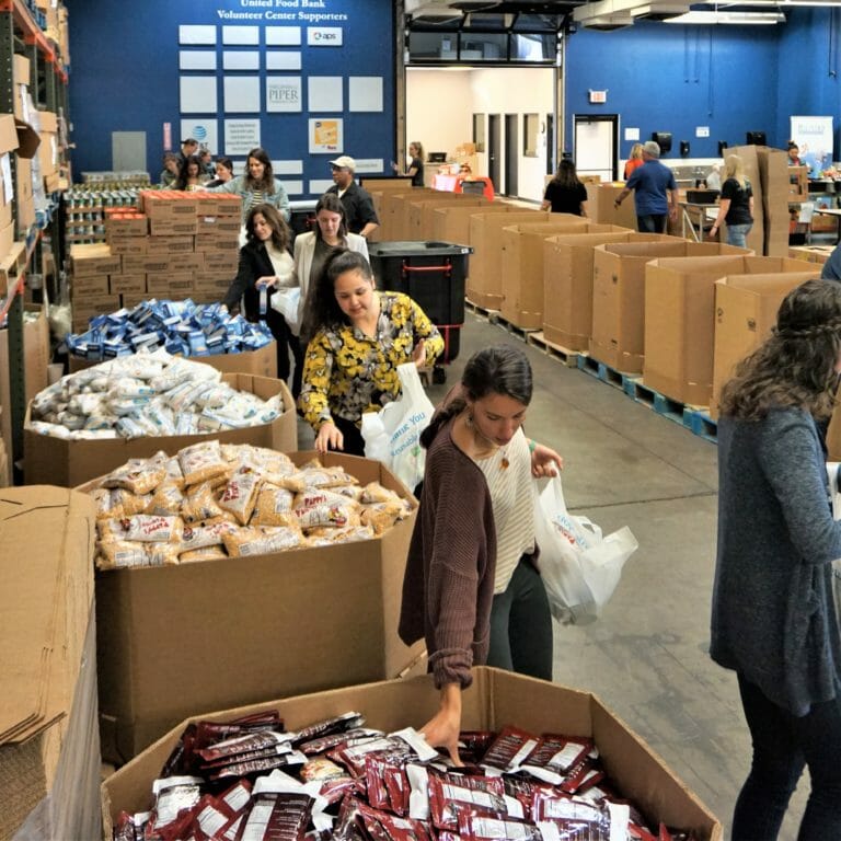People gathering food from bins at a food bank