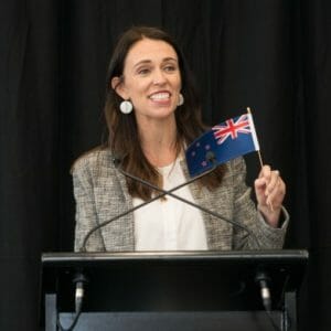 Jacinda Ardern waving New Zealand flag.
