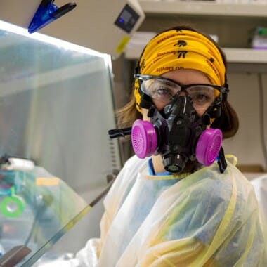 lab worker wearing protective gear developing covid saliva test