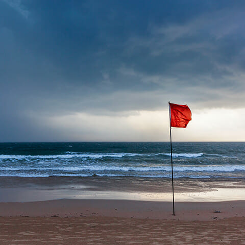 Hurricane red flag on a beach