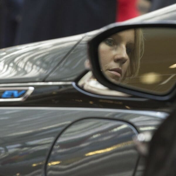Woman's face in side mirror of a car.