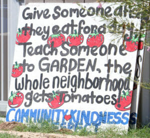 Sign that reads give someone a fish they eat for a day. Teach someone to garden, the whole neighborhood gets tomatoes.